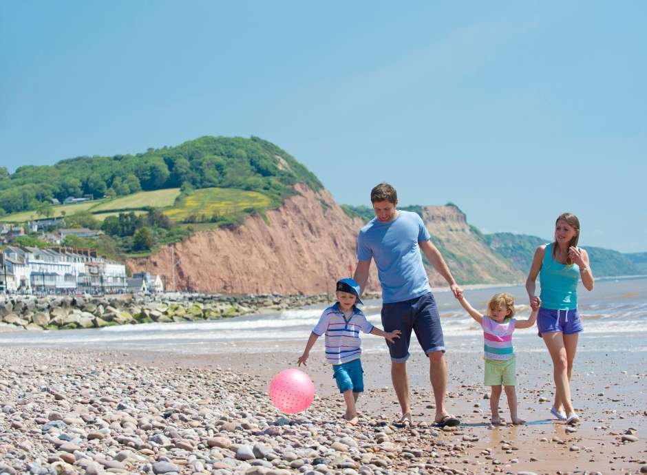 family of 4 walking on beach in Sidmouth